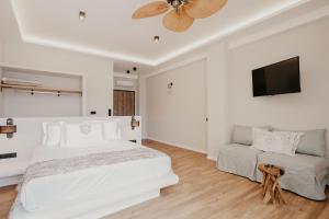 阿莫利亚尼岛Trinity Suites Ammouliani Hospitality的白色卧室配有床和平面电视