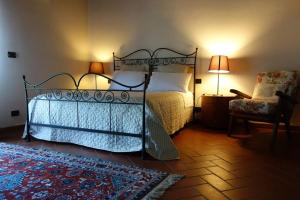 蒙特伦齐奥蒙特比贝莱酒店的一间卧室配有一张床、一把椅子和一盏灯