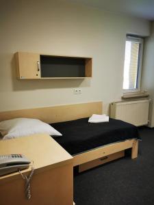 克拉科夫多姆学生胡同旅馆的卧室配有一张床铺,墙上配有电视