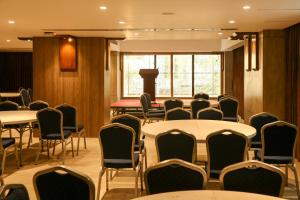 吉大港Pearl Harbour Business Hotel的一间会议室,配有桌椅和窗户