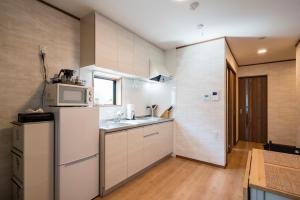 镰仓市KAMAKURA DEL COSTA的厨房配有白色冰箱和微波炉