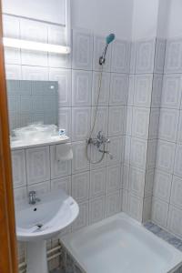 PucioasaHotel Turist的白色的浴室设有水槽和淋浴。