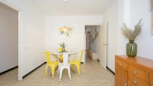 艾姆布里亚布拉瓦Empuriabrava Apartaments - nº7的一间带桌子和黄色椅子的用餐室