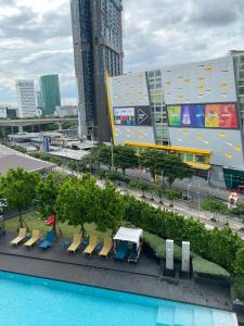 曼谷The Quarter Ladprao by UHG的享有带椅子和游泳池的建筑景致。