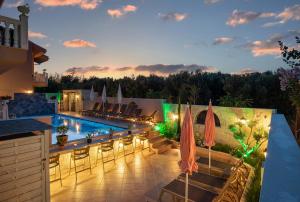 尼基季Kseynasa Suites的一个带游泳池和桌椅的度假酒店