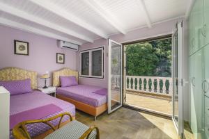 阿约斯尼奇塔斯VILLA PANOREA的客房设有紫色床和阳台。