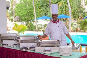 班布里蒙巴萨卡哈马酒店的厨师站在餐桌前,盘子