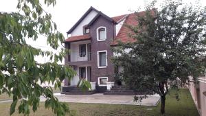 CricovaVila Family的前面有一棵树的大砖房子
