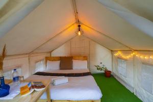 列城Bikamp Camp Leh Ladakh的帐篷内的卧室,配有一张床和一张桌子