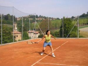 加比亚诺阿格丽图里斯摩卡别墅俱乐部酒店的一名女子在网球场上打网球