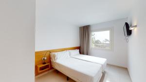 滨海托萨Villa Reymar - diseño y vistas al mar的一间小卧室,配有床和窗户