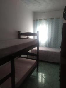 巴鲁埃里Quarto Triplo Solteiro的一间卧室设有两张双层床和一扇窗户。