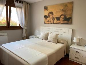 桑亨霍Mar y Sol的卧室配有一张白色床,墙上挂有绘画作品