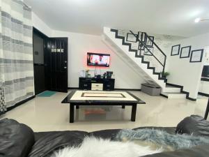 安吉利斯Balcony & 2BR TownHouse - near Clark Airport & Aqua Planet - TRP2的一间带桌子和楼梯的客厅