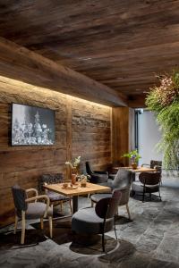 科尔蒂纳丹佩佐HOTEL de LEN的餐厅拥有木墙和桌椅