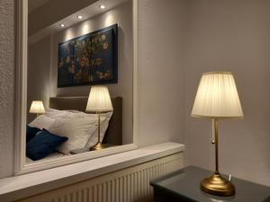 科莫蒂尼Mystique的一间卧室配有镜子和两张台灯