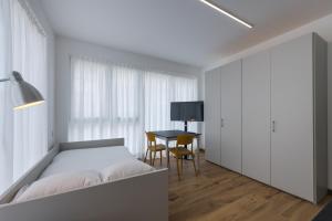 门德里西奥Modern Studios Mendrisio的白色卧室配有床和桌子