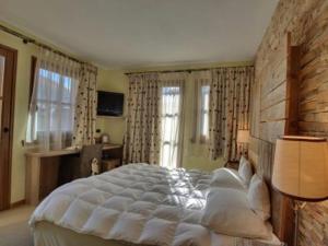 利维尼奥Hotel Bait de Angial的卧室设有白色大床和窗户。