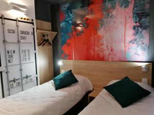 马蒂格Kyriad Direct Martigues的墙上画画的房间里设有两张床