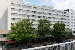 柏林SORAT Hotel Berlin的前面有树木的白色建筑