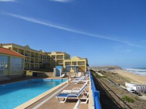 西尔维拉Hotel Apartamento Praia Azul的享有带游泳池和海滩的度假村景色