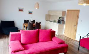 塔亚河畔拉镇Appartementhaus Thermeneck的一间带粉色沙发的客厅和一间厨房