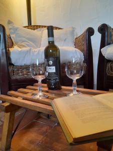 阿巴迪亚圣萨尔瓦托雷La Tana del Riccio的一张桌子上放着一瓶葡萄酒,放上两杯