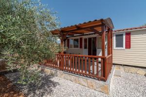 Djvulje'Olive grove' Camping House-near the beach的一个带木甲板的房子的门廊