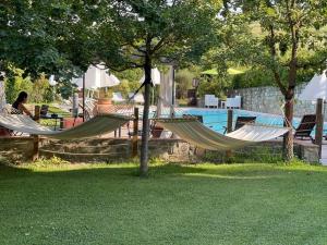 蒙泰斯佩尔托利Gatto Bianco Tizzauli的游泳池旁的庭院里设有两张吊床