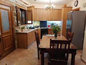 米里纳traditional house in Androni的厨房配有木制橱柜和桌椅