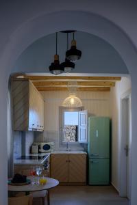 阿克罗蒂里Acro Blue Luxury Villas的厨房配有绿色冰箱和桌子