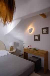 阿克罗蒂里Acro Blue Luxury Villas的一间卧室配有一张床和一张木桌