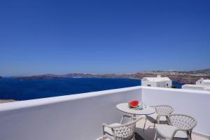 阿克罗蒂里Acro Blue Luxury Villas的海景阳台上的桌椅