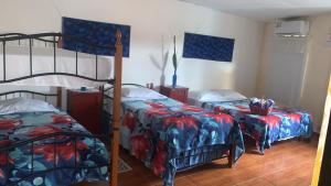 佩诺诺梅Hostal familiar Villa Nome的一间卧室配有两张双层床和一张带被子的床