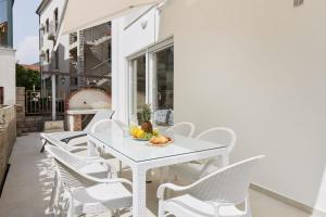 蒂瓦特Petrovic apartmani的庭院里的白色桌椅