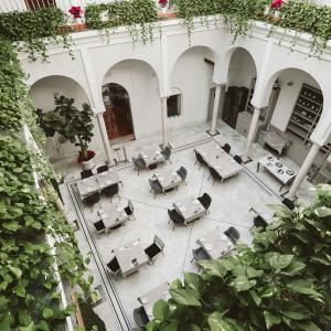 塞维利亚皮内罗宫酒店的享有带桌椅的庭院的顶部景致。
