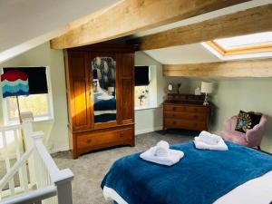 哈沃斯Tipple Cottage的一间卧室配有一张床,上面有两条毛巾