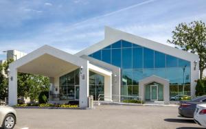 魁北克市奥伯格魁北克酒店的一座大型玻璃建筑,停车场内有车辆停放
