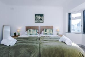 布兰博罗Woodyear Road的一间卧室配有一张带绿色床单的大床