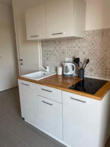 皮兰Apartments CLIFF Piran的厨房配有白色橱柜和水槽