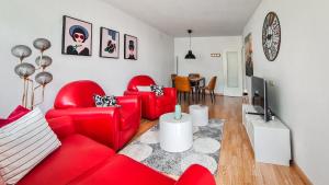 施卢赫湖black-forest holiday - Ferienresort am Schluchsee的客厅配有2把红色椅子和电视