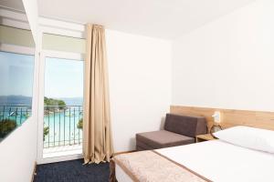 穆泰尔岛Colentum Resort Murter的酒店客房设有一张床和一个阳台。