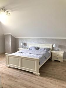 TelciuPensiunea Sofia的卧室配有白色的床和2个床头柜