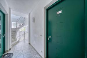 布鲁尼科City Café - CENTRAL Apartment的走廊上的绿色门,有楼梯
