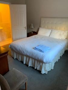 韦斯特波特Ceol Na Mara的一间卧室配有一张白色的床,上面有蓝色的毛巾