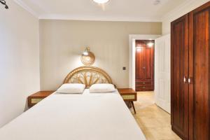 卡斯尼尔瓦纳公寓的卧室配有一张白色大床和木制橱柜。