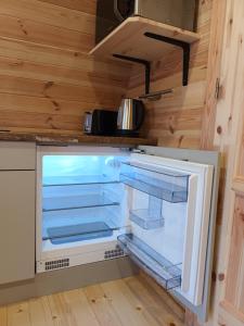 巴利卡斯尔Ceide Glamping的一个小房子的厨房里的一个空冰箱