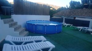 卡斯特里尔Alojamiento Rural El Molino De La Cerrada的庭院设有热水浴池和2个白色长椅