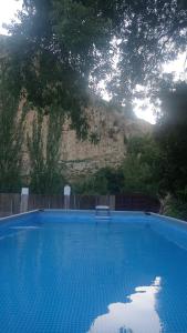 卡斯特里尔Alojamiento Rural El Molino De La Cerrada的山前的大型蓝色游泳池