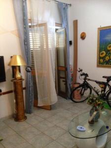 维博瓦伦蒂亚码头La Casetta Bianca Vicino Mare的墙上有桌子和自行车的房间